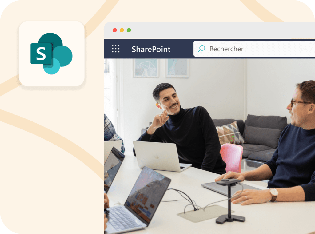 Deux consultants d’une agence SharePoint discutent dans une salle de réunion, assis autour d’une table avec plusieurs ordinateurs portables, pendant qu’une interface SharePoint s’affiche en surimpression à gauche de l’image.